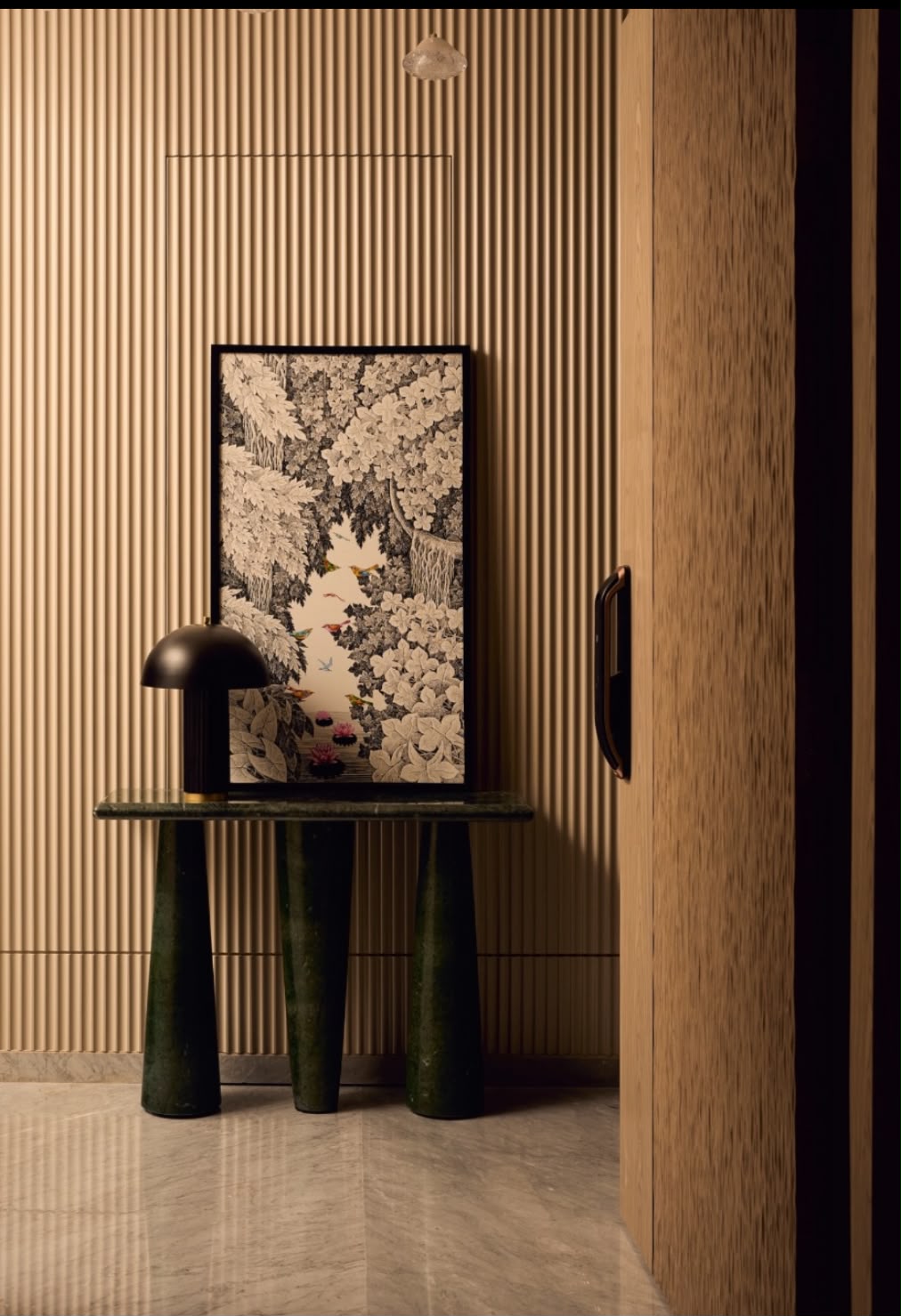 Console table with a black lamp and a framed botanical print against fluted timber panelling
